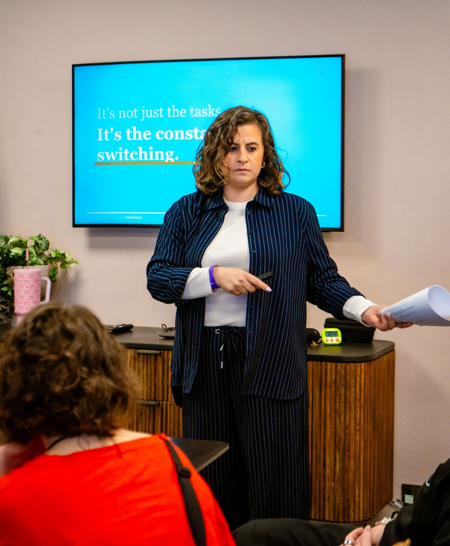 Kate Keir presenting to an audience, slide reading 'It's not just the tasks. It's the constant switching.'